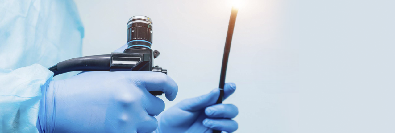 Duas mãos segurando um aparelho de endoscopia e videocolonoscopia