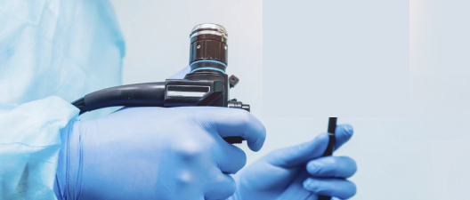 Duas mãos segurando um aparelho de endoscopia e videocolonoscopia